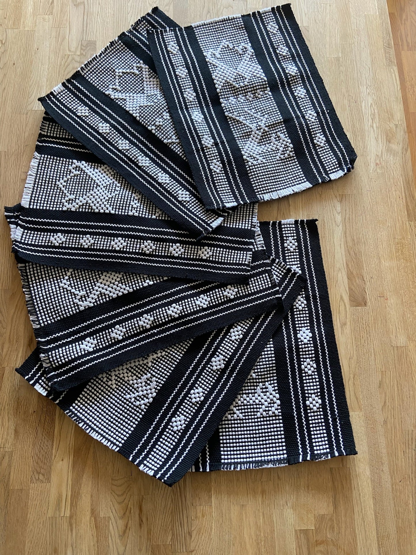 Juego de camino de mesa tejido a mano y 8 manteles individuales en negro con brocados en blanco